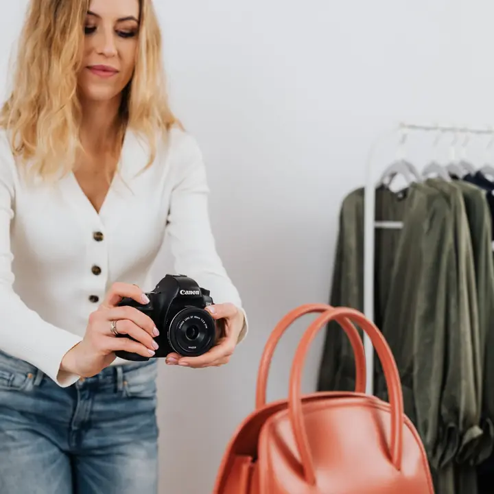 Creator photographing an orange handbag for a brand shoot